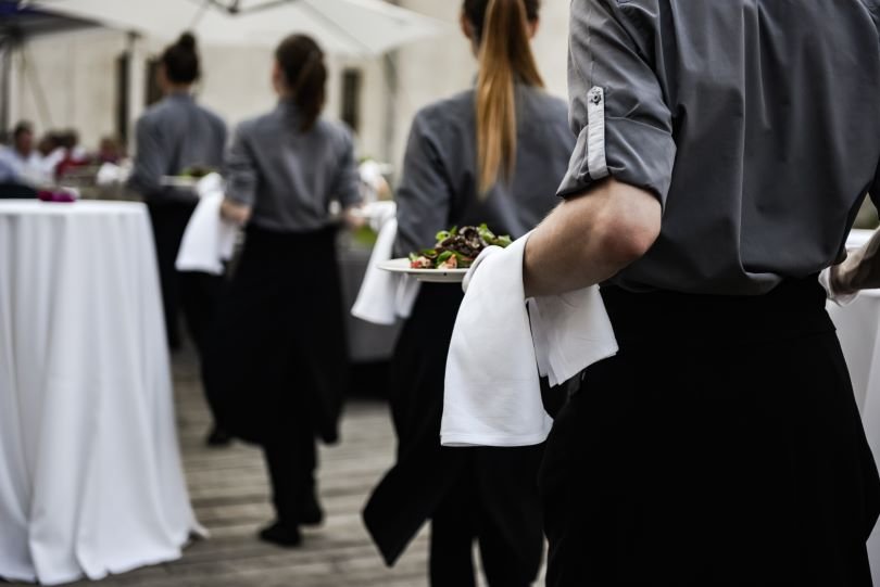 Servers-in-a-line-holding-trays-What-is-Fine-Dining-Etiquette-for-Servers